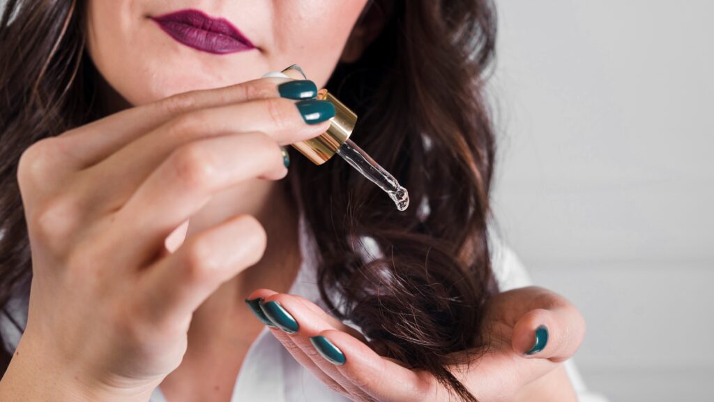 A woman is taking care of her hair using hair serum.